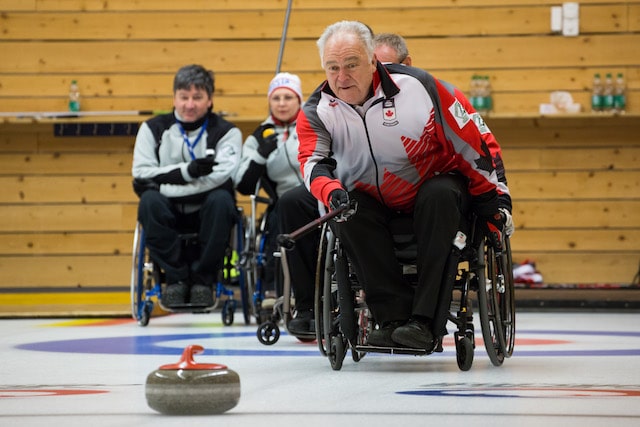 Team Canada skip Jim Armstrong delivers his rock against Norway at the World Wheelchair Curling Championship in Lucerne, Switzerland (WCF/Céline Stucki photo)