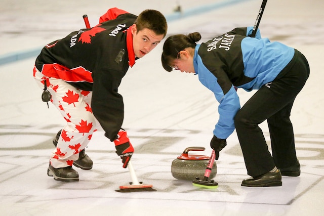 Tyler Tardi and teammate Honoka Sasaki of Japan sweep their rock to the house during Mixed Doubles play at the Youth Olympic Games in Lillehammer, Norway (WCF/Richard Gray photo)